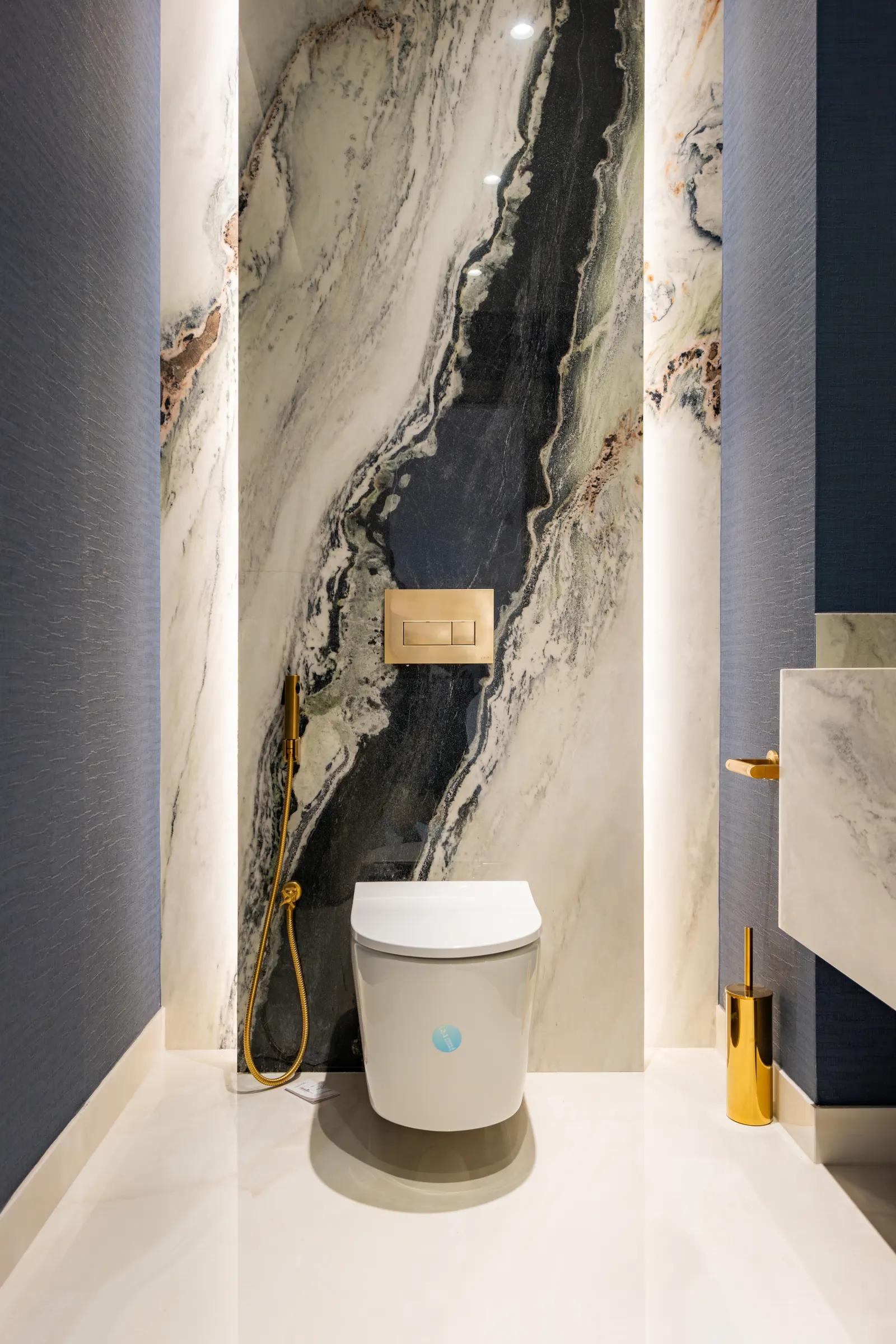 Alwan Fit-out renovation, Al Barsha villa cloakroom. Marble feature wall, brushed gold, deep navy walls.